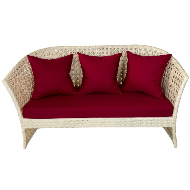 Wicker loveseat with red cushions on a white background