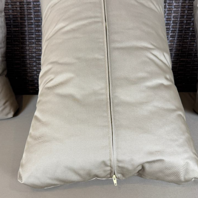 Beige pillow with a zipper on a couch