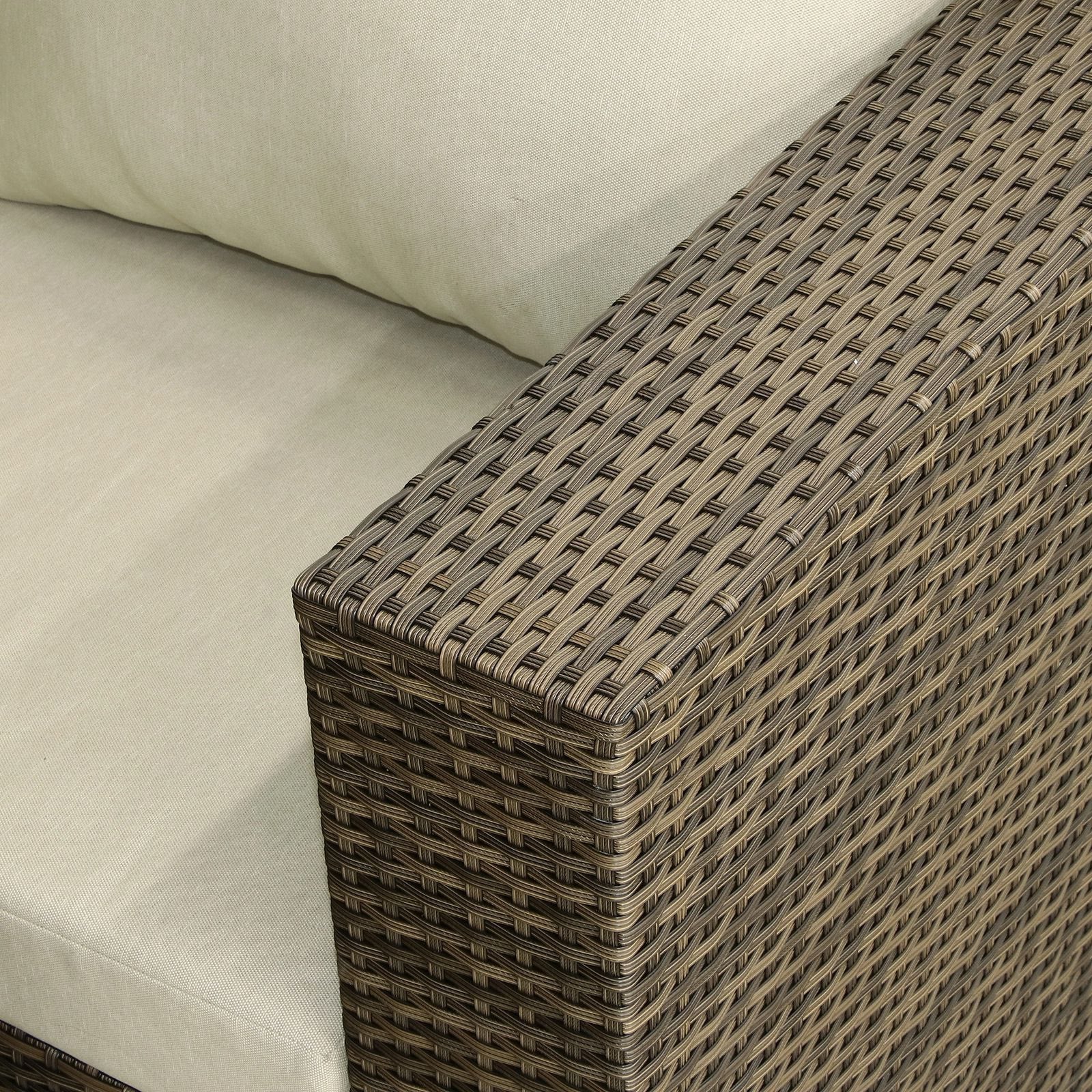 Corner of a wicker outdoor sofa with beige cushions