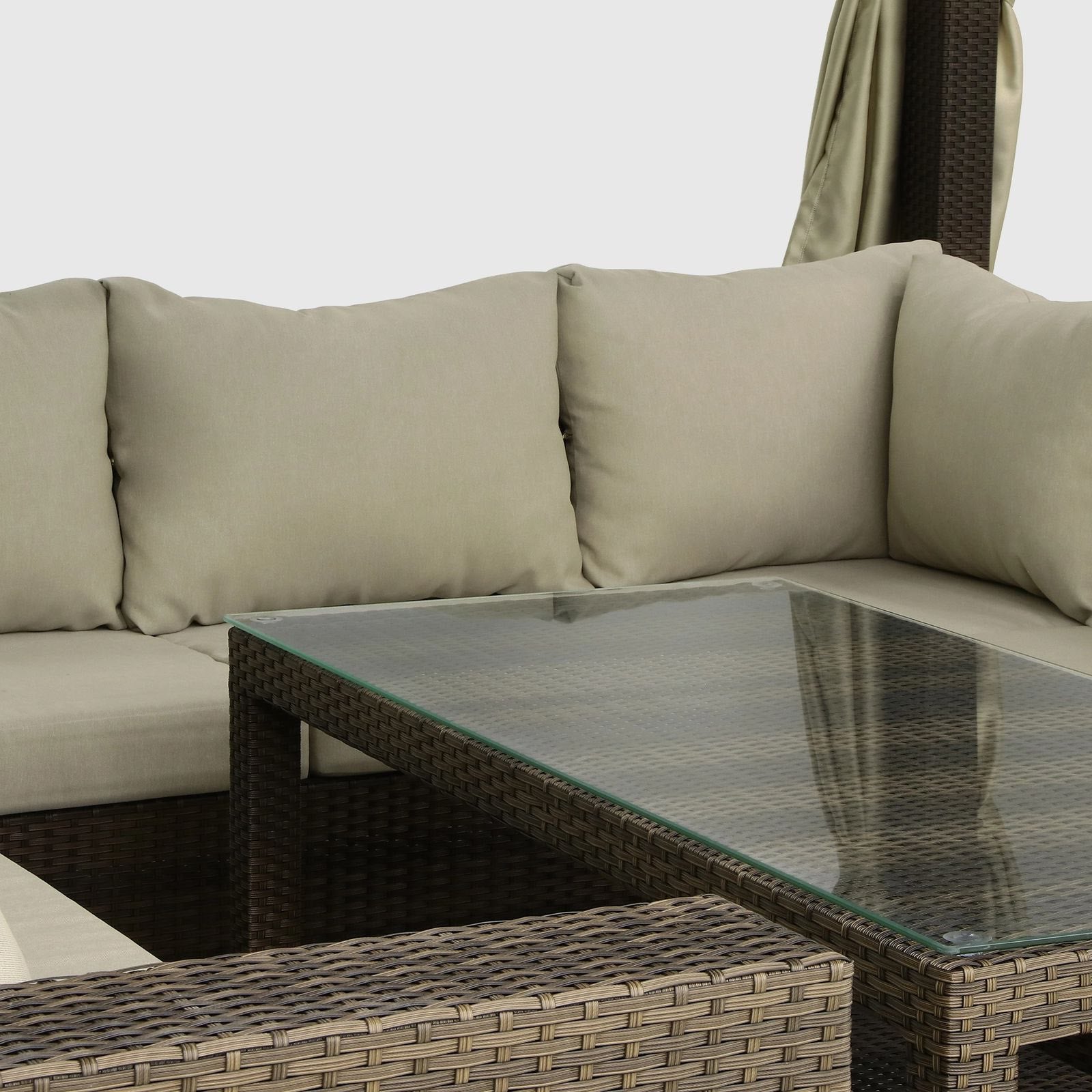 Outdoor furniture set with a glass-top table and beige cushions.